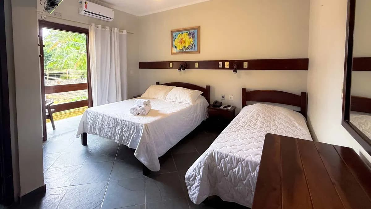 Quarto do Villa'l Mare Hotel com cama de casal, cama de solteiro, ar-condicionado e porta para a varanda