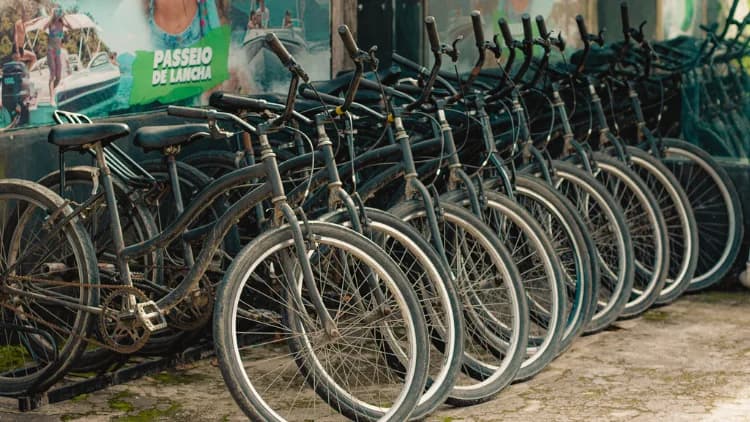 Fileira de bicicletas estacionadas lado a lado no bicicletário, prontas para o passeio de bike em Maresias, São Sebastião